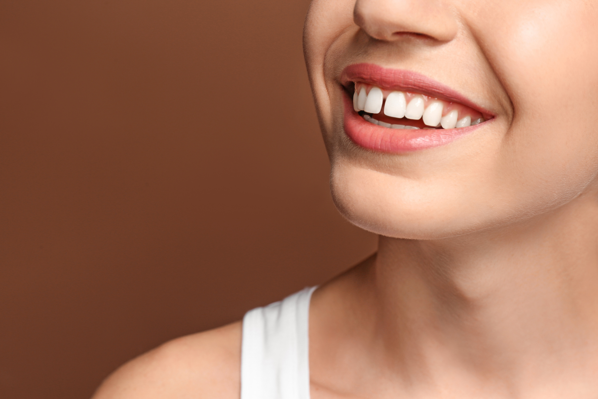 Young Woman with Beautiful Smile on Color Background. Teeth Whit
